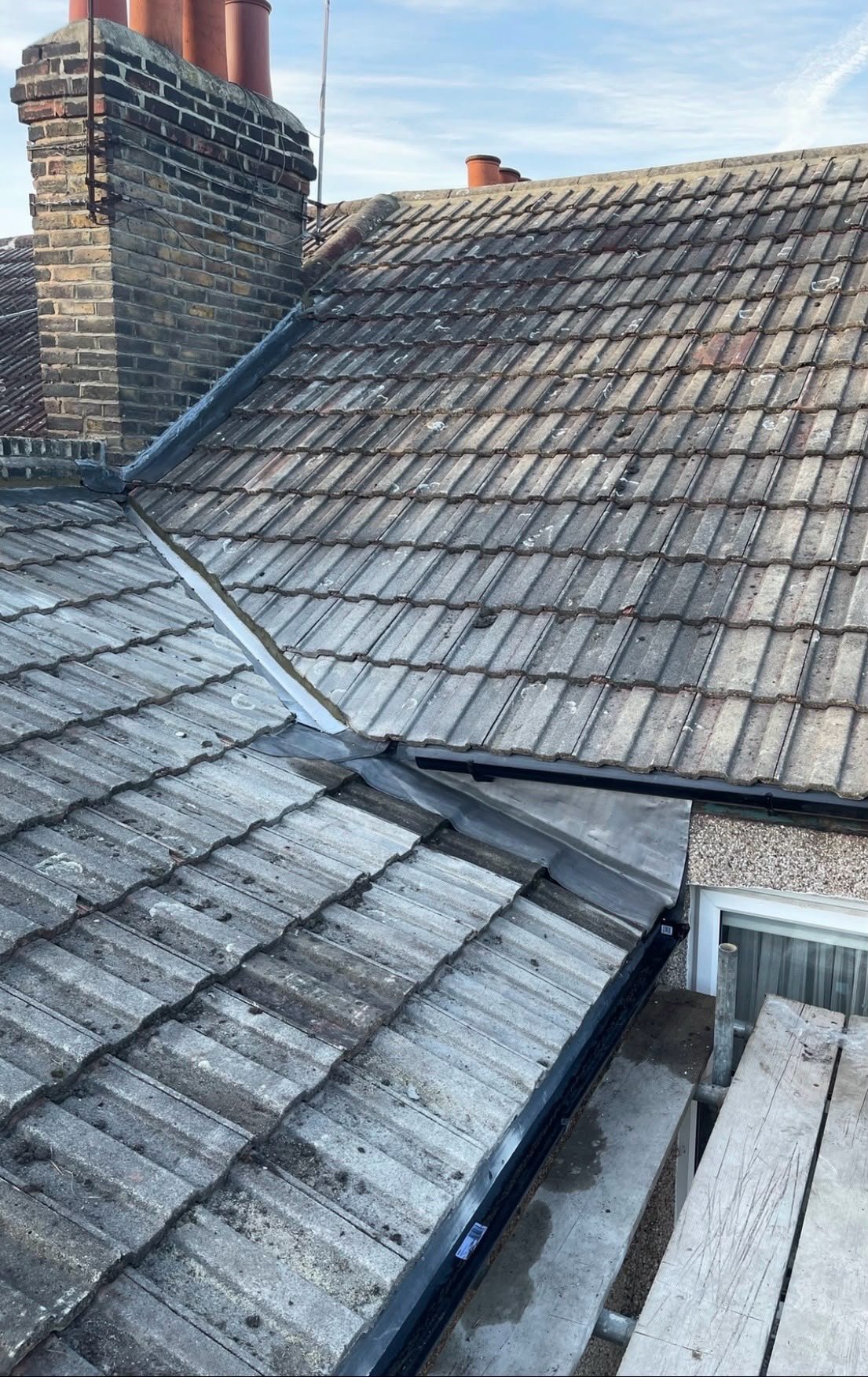 Grey concrete tiled roof with a valley and dormer