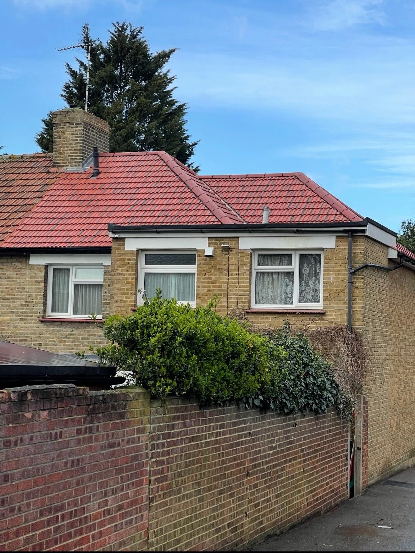 Semi-detached house with a red tiled pitched roof, a recent Abode Roofing job