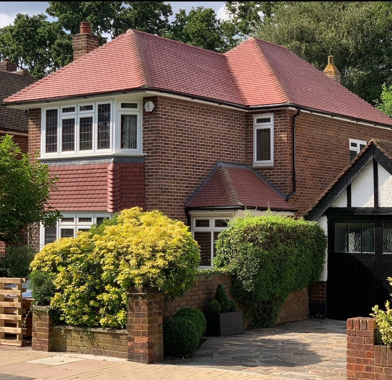 Red brick house with a red tiled roof and gable